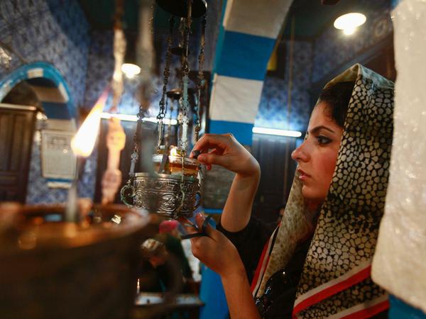 Eine gläubige Jüdin entzündet eine Öllampe in der Synagoge El Ghriba auf Djerba, Tunesien. 