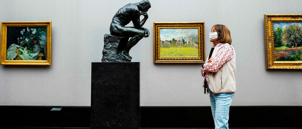 Eine Besucherin der Alten Nationalgalerie schaut dem "Denker" des französischen Bildhauers Auguste Rodin beim Denken zu.