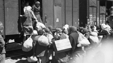 Frauen und Mädchen, die unter deutscher Bewachung in einen Waggon steigen, um zur Zwangsarbeit nach Deutschland verschleppt zu werden, aus der Ukraine im Frühjahr 1943.