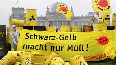 "Schwarz-Gelb macht nur Müll" steht auf einem Transparent, daneben wehen "Atomkraft?-Nein Danke"-Fahnen bei einer Aktion von Anti-AKW-Aktivisten imRegierungsviertel in Berlin bei einer Demonstration gegen die Kernenergie vor dem Reichstag. 