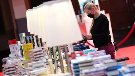 Viele Bücherstapel, wenig Besucher. Eine Mitarbeiterin der Frankfurter Buchmesse an einem Verlagsstand in der Festhalle. 