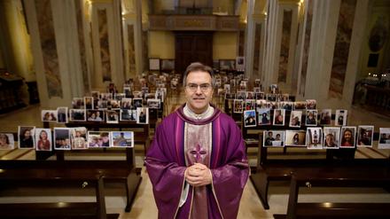 Auch Kirchen sind von den Einschränkungen betroffen. Pfarrer Don Giuseppe Corbari vor den Selfies seiner Gemeindemitglieder.
