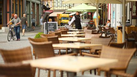 Ein Kellner deckt in Wernigerode, Sachsen-Anhalt, die Tische des Außenbereichs. 
