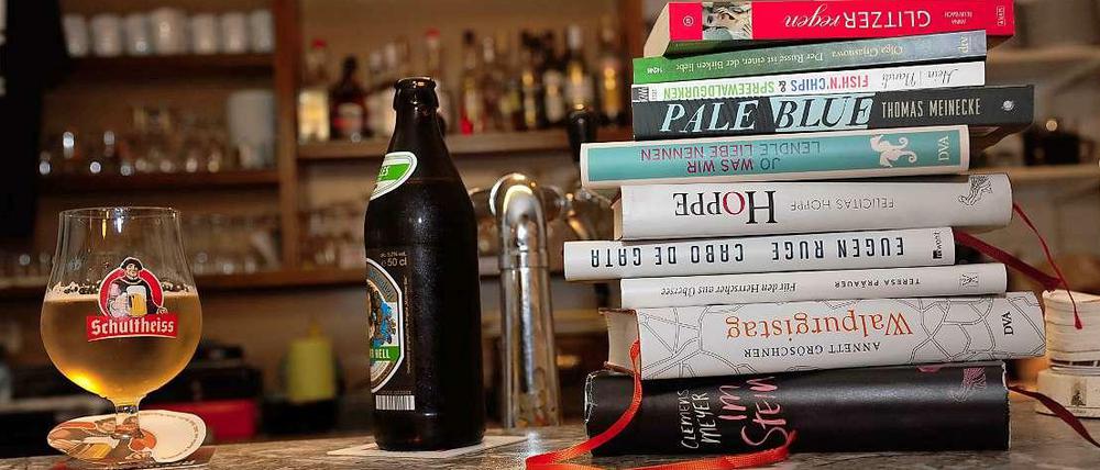 Eine Theke in einer Bar auf der Bücher und zwei Bier stehen. 