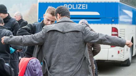 Ein Flüchtling wird am 04.11.2015 an der deutsch-österreichischen Grenze nahe Wegscheid (Bayern) von einem Bundespolizisten durchsucht. 