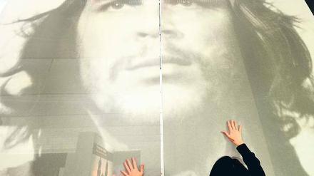 Streicheleinheiten für den Star. Eine Buchmessen-Mitarbeiterin sorgt dafür, dass Che Guevara das Treiben im Argentinien-Pavillon faltenfrei beobachten kann. Foto: dpa/Boris Roessler