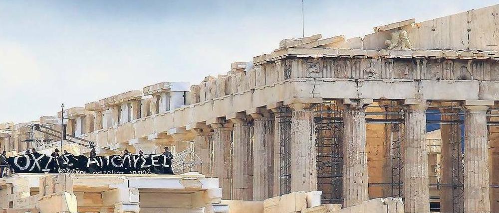 Erhabene Baustelle. Touristen auf der Akropolis – und ein Transparent, das gegen die Sparpolitik der Regierung protestiert. 