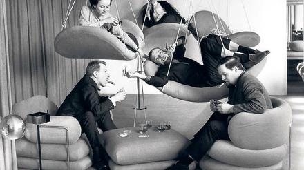 Schöner liegen. Verner Panton (Mitte, mit Bart) posiert 1964 für ein Frankfurter Möbelhaus in seinen Entwürfen. Foto:dpa/Roland Witschel