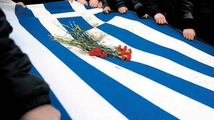 Nekrolog im November 2011. Studenten tragen in Athen die griechische Flagge zu Grabe. Foto: Alkis Konstantinidis, dpa