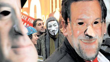 Occupy Madrid. Erster Protest gegen die Reformen von Präsident Mariano Rajoy, dessen Maske rechts zu sehen ist.