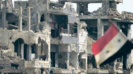 Furor der Zerstörung. Ansicht eines Straßenzugs Anfang Mai im Quartier Baba Amr in Homs mit syrischer Flagge. Das Bild entstand während einer von der Regierung geführten offiziellen Tour durch die einstmalige Hochburg der Widerständler. 