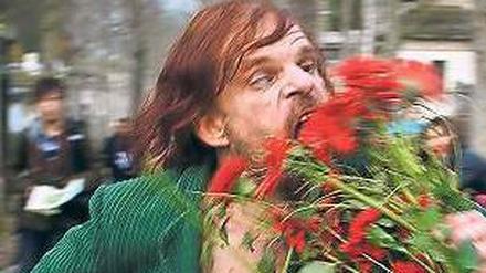Maskenspieler. Monsieur Merde (Denis Lavant) futtert Friedhofsblumen. 
