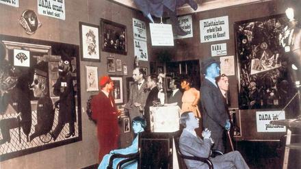 Kunst und Aktion. 1920 wurde in Berlin die „1. Internationale Dada-Messe“ eröffnet. Wieland Herzfelde (stehend, ganz rechts). Zugegen waren u. a. auch Raoul Hausmann, George Grosz, John Heartfield und Hannah Hoech. Foto: picture alliance/akg-images