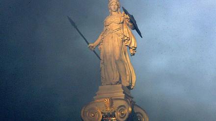 Umkämpfte Heldin. Statue der griechischen Göttin Athene in Athen, nach einer Demonstration von Tränengas umhüllt.