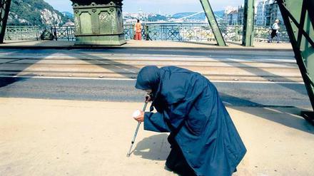 Land an Krücken. 1989, als der Eiserne Vorhang fiel, fühlte sich Ungarn im Aufwind. Inzwischen schlagen sich viele Menschen – wie diese greise Bettlerin auf der Freiheitsbrücke in Budapest – unterhalb der Armutsgrenze durch. 