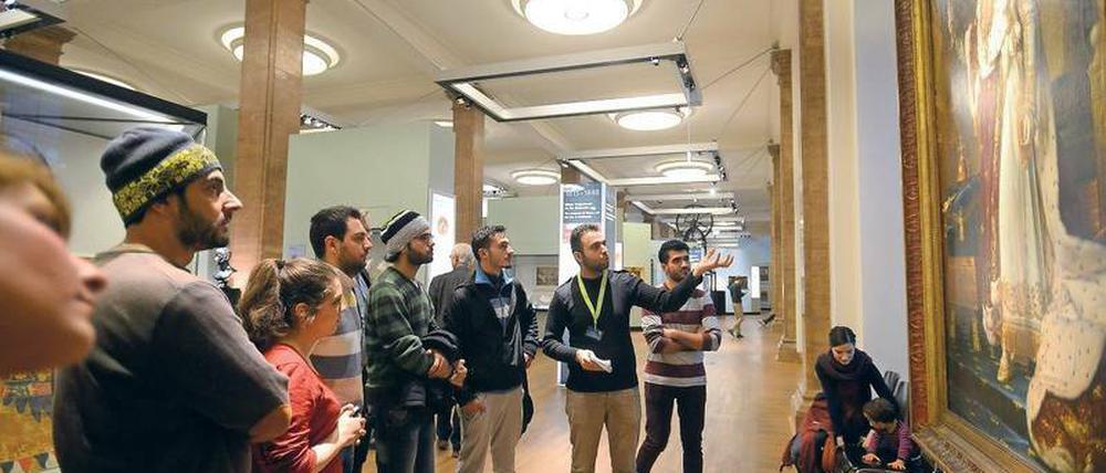 Gute Sicht. Bashar Almahfoud (mit grünem Bändchen) bei seiner Führung auf Arabisch im Deutschen Historischen Museum vor einem Bild Napoleons im Rahmen des Projekts "Multaka - Treffpunkt Museum". 