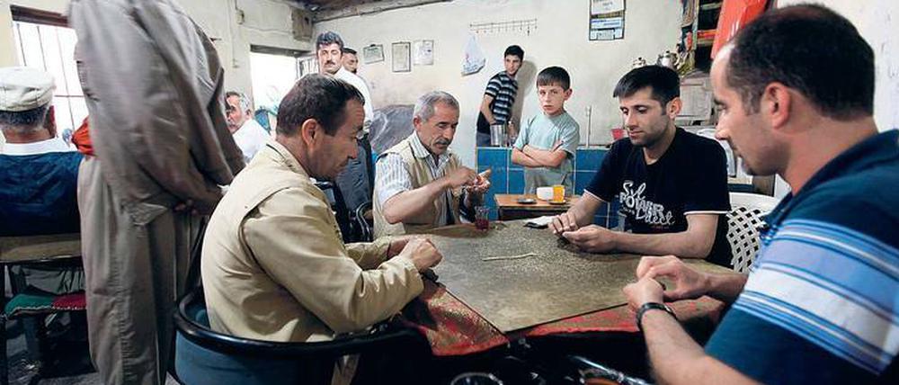 Geschlossene Gesellschaft. Domino spielende Männer in einem türkischen Teehaus.