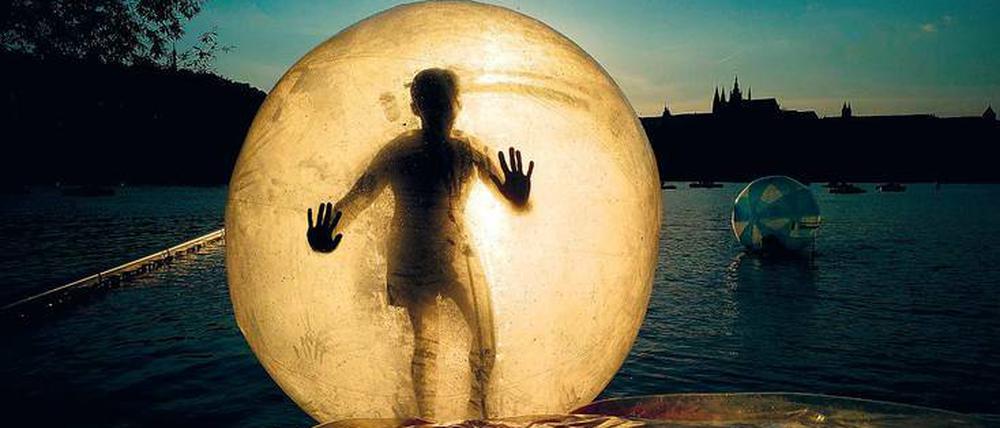 Weltraumgefühl. Ein Prag-Tourist schwebt in einem luftgepolsterten Riesenball über die Moldau. 