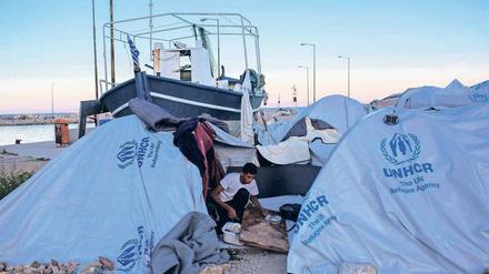 Am Hafen gestrandet. Ein Migrant säubert vor seinem Zelt am Flüchtlingslager Souda auf Chios ein Brett, auf dem er schlafen will. 
