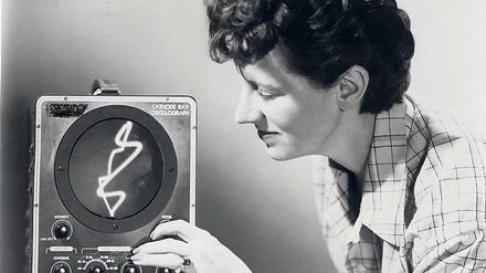 Die Filmemacherin Mary Ellen Bute mit einem Oszilloskop, das elektrische Spannung in einem Koordinatensystem darstellt.