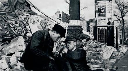 Zwei Männer gönnen sich im Dezember 1948 in den Ruinen Berlins eine Zigarette. Nikotin war damals nicht leicht zu bekommen. 