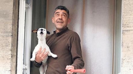 Ein Mann und sein Hund in Rom sind an ihrem Fenster Teil eines Flashmobs gegen die Einsamkeit in den Zeiten von Corona. 