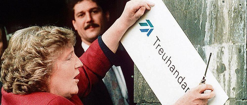 Die scheidende Präsidentin Birgit Breuel entfernt am Jahresende 1994 das Schild am Eingang der Treuhandanstalt in Berlin. 