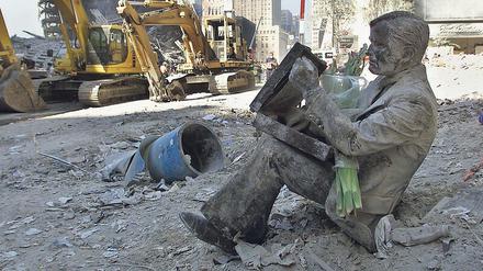 Sitzender Mann, ratlos. Eine Skulptur in Manhattan, die mit der Asche der niedergebrannten Zwillingstürme bedeckt ist. Die Aufnahme stammt vom 13. 9. 2001. 