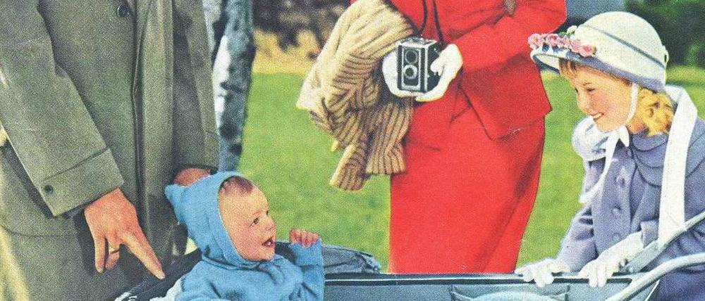 Glückliche 50er-Jahre-Familie rund um einen Kinderwagen mit Baby.