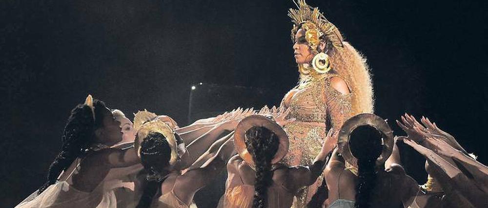 Neben Adele der große Star des Grammy-Abends. Die schwangere R&amp;B-Künstlerin Beyoncé, wie sie sich von ihren Dienerinnen hochleben lässt.