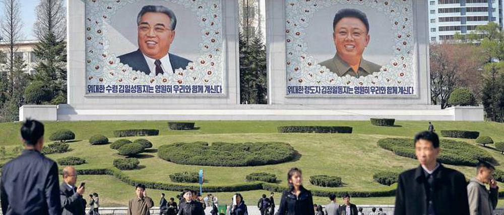 Alte Helden. Straßenszene in Pjöngjang, unter Aufsicht der Ex-Präsidenten Kim Il-sung und Kim Jong-il.