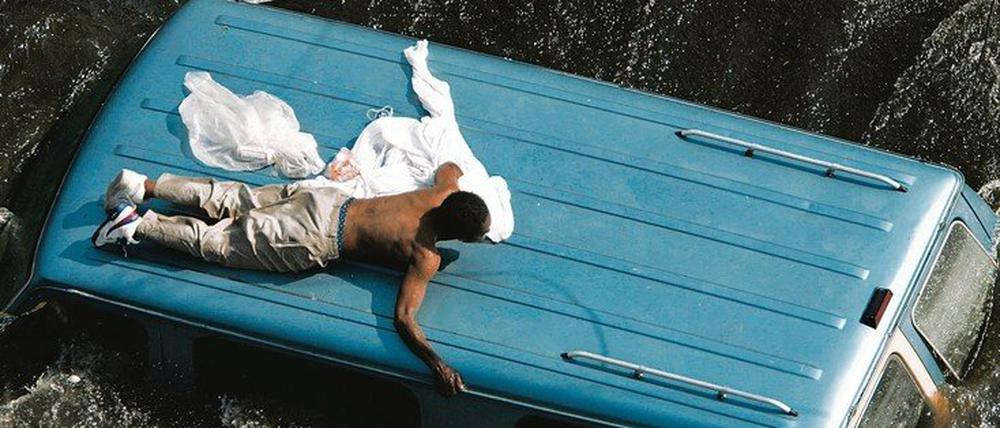 Warten auf Rettung. Ein Bewohner von New Orleans versucht, sich von Fluten nicht wegspülen zu lassen, die Hurrikan Katrina im September 2005 mit sich brachte.