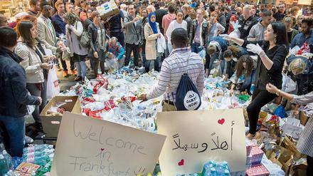 Hunderte Freiwillige bringen Lebensmittel, Getränke und Kleidung in den Hauptbahnhof in Frankfurt am Main, um Flüchtlinge willkommen zu heißen. 