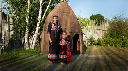 Ojibwe-Mutter und -Tochter im traditionellen Kleid in einem Native-Dorf in Midland, Ontario. 