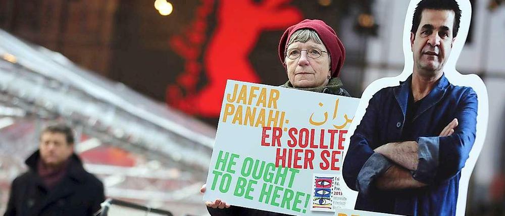 Berlinale 2013: Eine Demonstrantin hält einen Protestbanner mit der Aufschrift: "Jafar Panahi: Er sollte hier sein." Im Wettbewerb lief sein Film "Geschlossener Vorhang", 2015 ist er mit "Taxi" eingeladen.