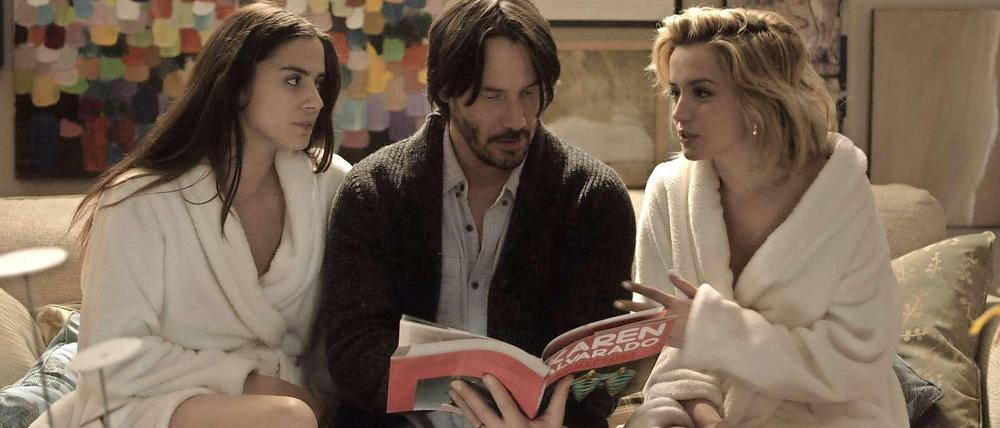 Genesis (Lorenza Izzo), Evan (Keanu Reeves) und Bel (Ana De Armas) betrachten das Kunstbuch seiner Frau.