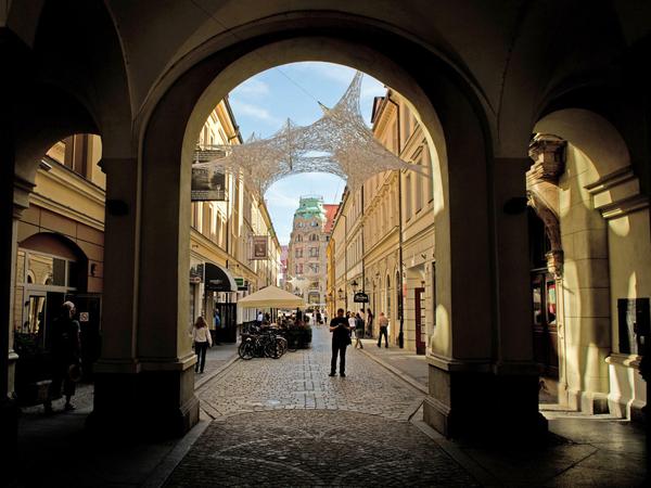 Ein Torbogen gibt in der Altstadt von Wroclaw (Breslau) den Blick auf eine Kunstinstallation frei. 