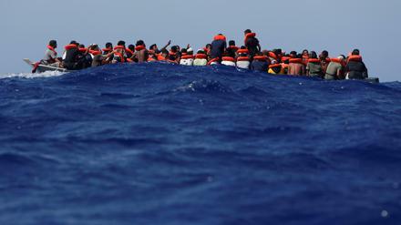 Auf lebensgefährlichen Wogen. Flüchtlinge auf einem Holzboot vor Lampedusa warten auf die Rettung durch die deutsche Sea-Watch und die italienische Küstenwache. 