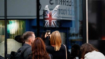 Londoner Passanten versammeln sich vor dem Schaufenster des Banksy-Shops, in dem auch die berühmte Stormzy-Weste ausgestellt ist.
