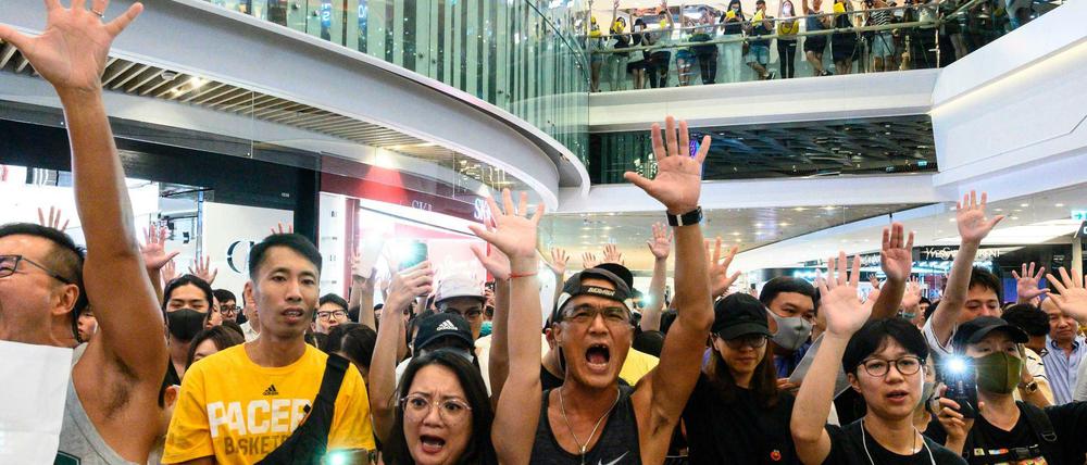 Singen statt Shoppen: Eine Menschenmenge stimmt in einem Einkaufszentrum „Glory to Hong Kong“ an.