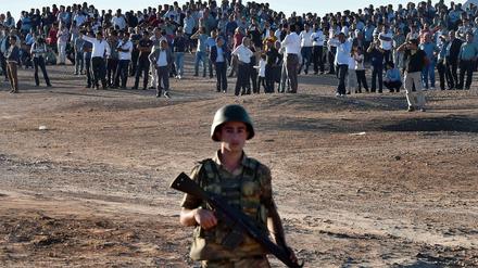 Kurds are gathering oppisite the syrian city of Kobane or Ain al Arab. The city is surrounded by the "Islamic State" and the people of the turkish side fear a massacre. 