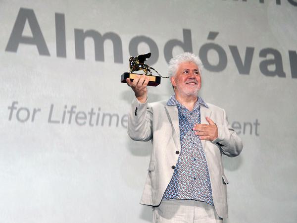 Regisseur Pedro Almodovar hält den Goldenen Löwen für sein Lebenswerk in die Luft.