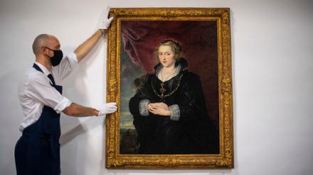Ein Mitarbeiter des Auktionshauses Sotheby's mit einem Frauenporträt, das jetzt Peter Paul Rubens zugeschrieben wird.