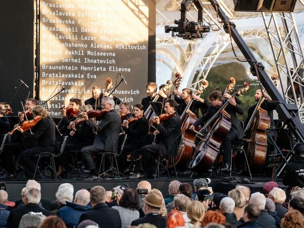 Das Deutsche Symphonie-Orchester Berlin spielt zu Beginn der Gedenkfeier Schostakowitschs 13. Symphonie "Babij Jar". Im Hintergrund laufen die Namen der Toten. 