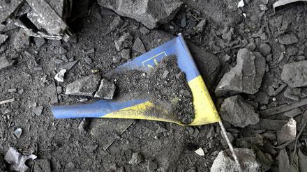 02.06.2022, Ukraine, Charkiw: Eine ukrainische Fahne liegt nach einem Raketeneinschlag in den Trümmern. Beim Einschlag einer russischen Rakete in eine Schule in der ukrainischen Stadt Charkiw wurden am 02.06.2022 eine Frau getötet und mehrere Personen verletzt. 