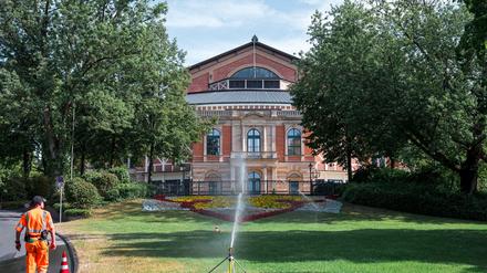 Ein städtischer Mitarbeiter bewässert die Grünfläche vor dem Festspielhaus vor Beginn der Bayreuther Festspiele.