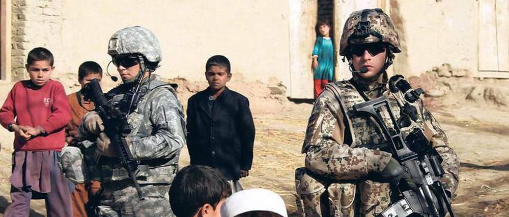 Getrennte Wege? Ein Soldat der US Army (li.) und einer der Bundeswehr patrouillieren bei einer gemeinsamen Mission in Afghanistan. 