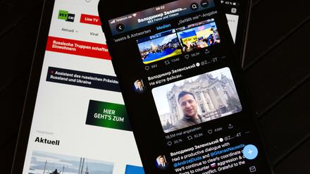 Auf dem Bildschirm eines Tablets (l.) ist die Website des russischen Fernsehsenders RT zu sehen. Rechts ist auf dem Bildschirm eines Smartphones der offizielle Twitter-Account des ukrainischen Präsidenten Selenskyj zu sehen.