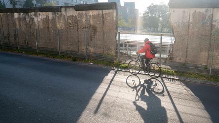 Ein Radfahrer fährt am Morgen an einem Mauerstück an der Gedenkstätte «Topographie des Terrors» vorbei.