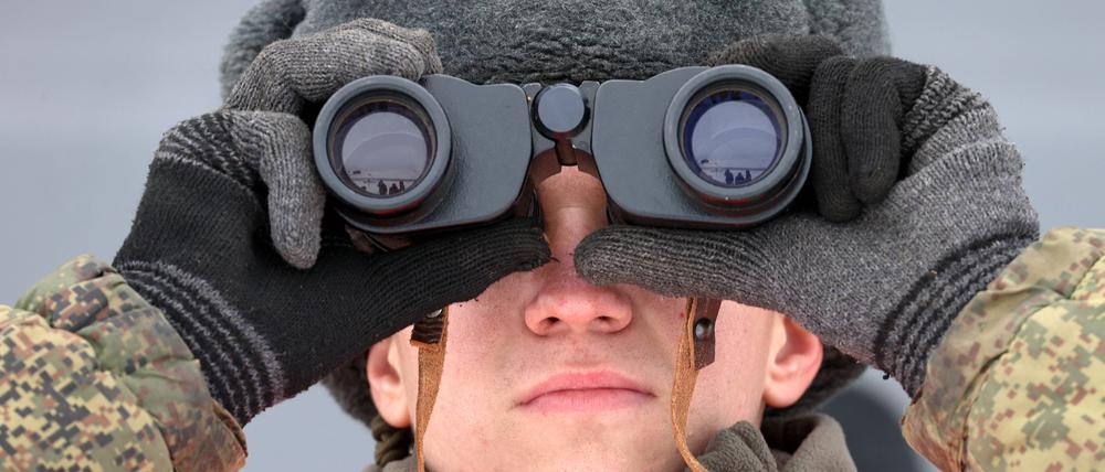 Ein russischer Soldat beobachtet ein Truppenmanöver.  